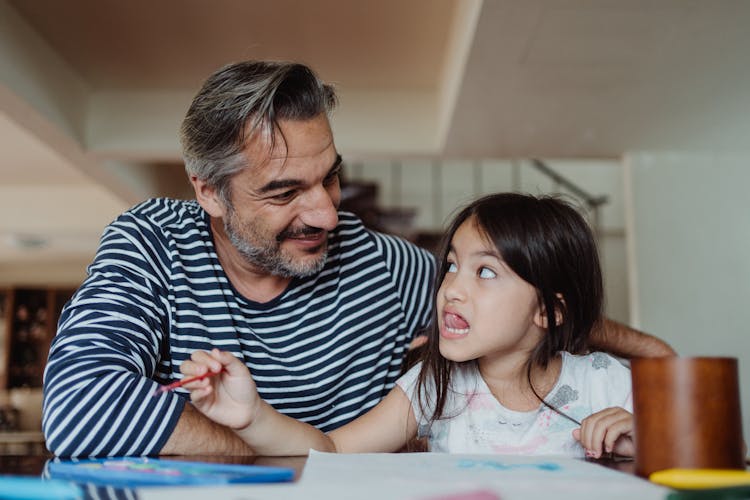 Girl Looking At Her Father With Her Tongue Out