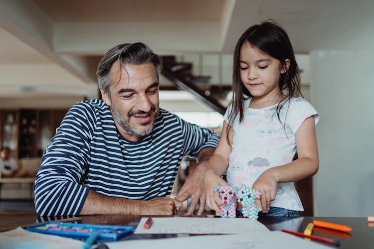 Girl Showing Her Drawings and Toys To Her Father 