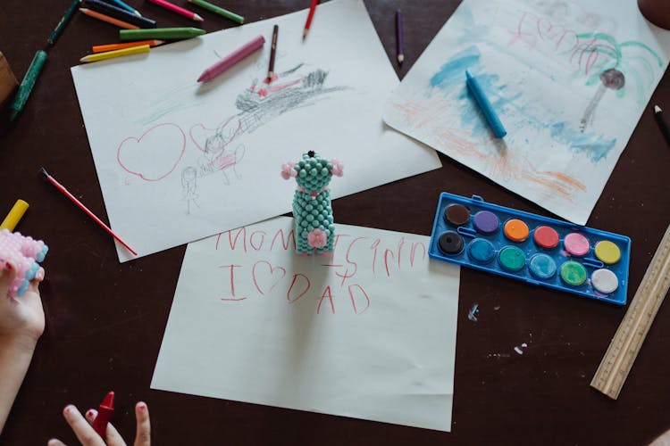 Childs Drawings Scattered On Desk