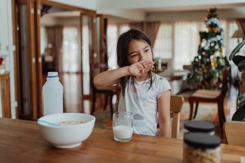 Little Girl Rubbing Her Face During Breakfast