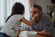 父女俩在室内共享有趣的早餐时光，展现了温馨的家庭纽带