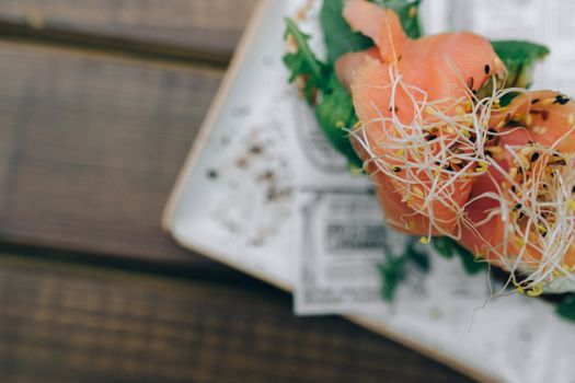 Close-up of fresh salmon sashimi garnished with sprouts, showcasing vibrant colors.