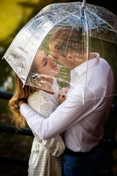 这对恩爱的夫妇在雨中撑着透明伞，共享亲密时刻