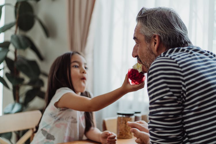 Girl Giving Cake To Father