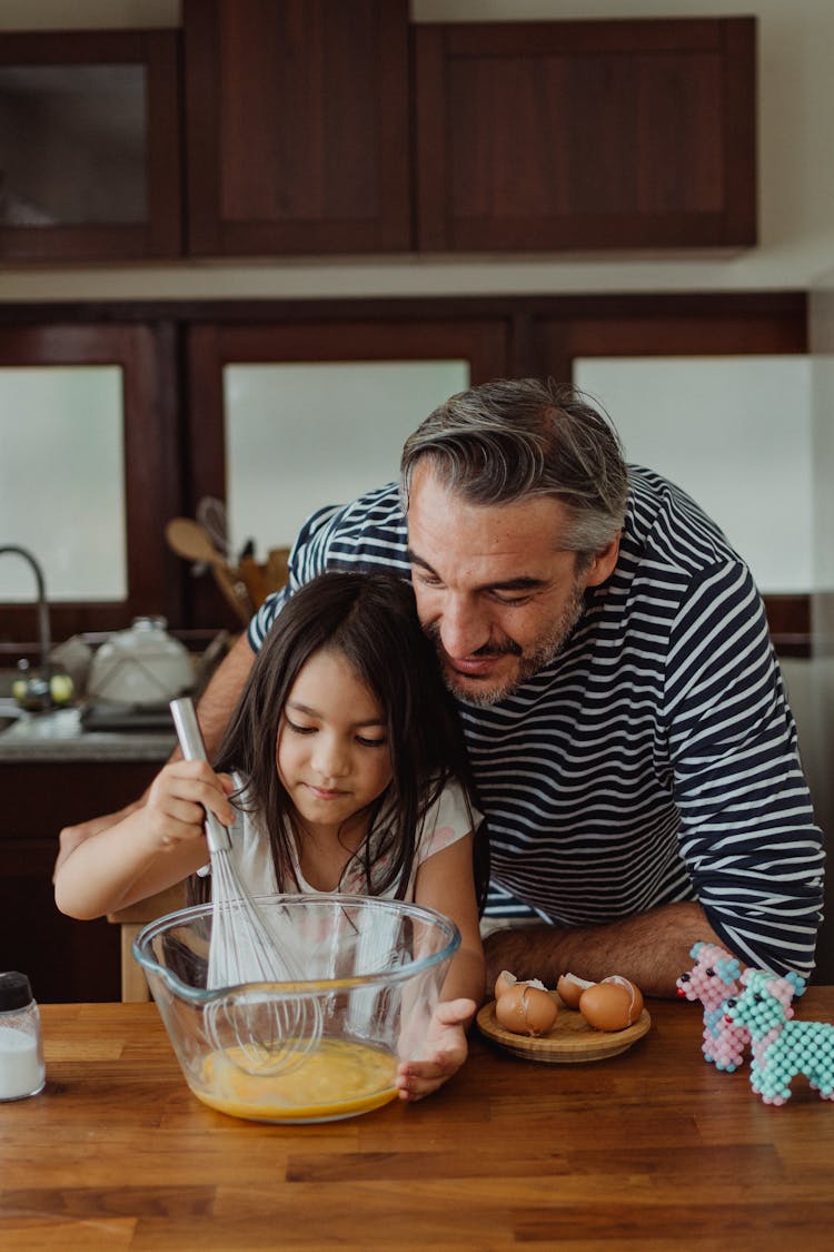 Father Watching Daughter Mix Eggs