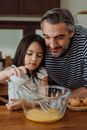 Father and Daughter Preparing Scrambled Eggs in Kitchen