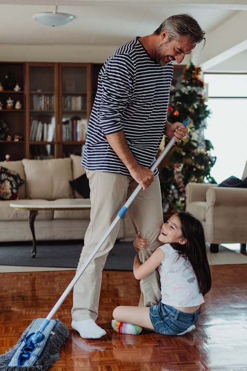 Free Father and Daughter Mopping and Playing at Home Stock Photo