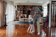 父女俩在温暖舒适的客厅里快乐地共舞