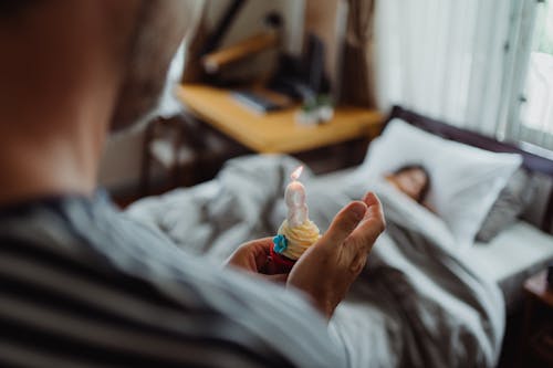 Father Holding a Birthday Cupcake with a Candle in Daughters Bedroom 