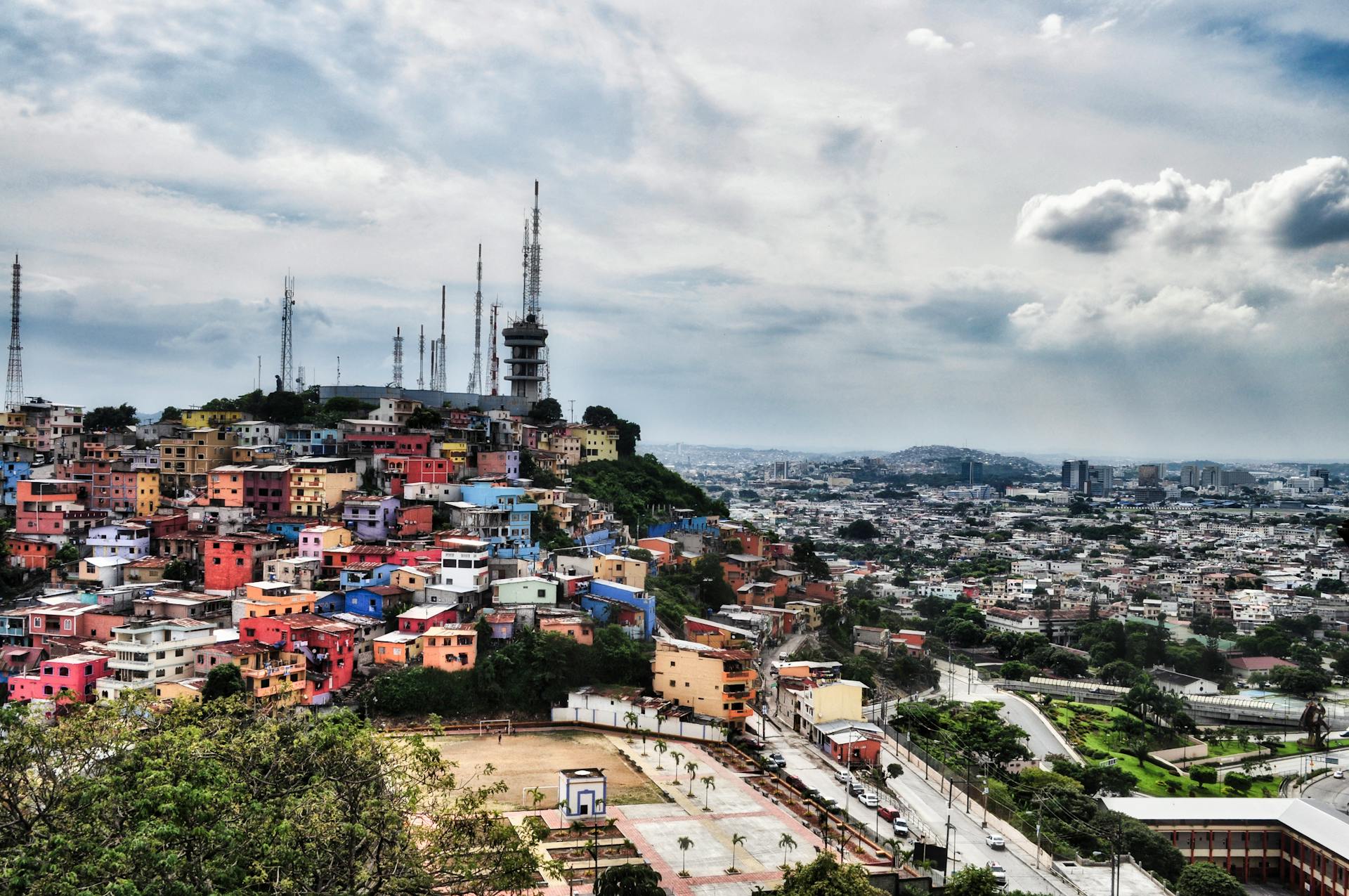 Aerial view of the vibrant Santa Ana Hill neighborhood in Guayaquil, Ecuador with cloudy skies.