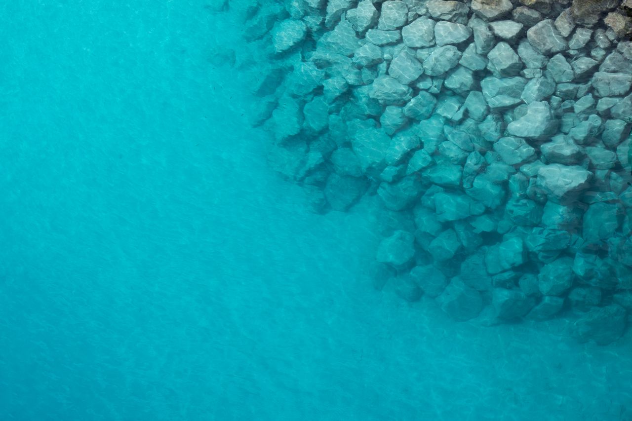 stunning aerial view of rocky shoreline blending into the clear turquo