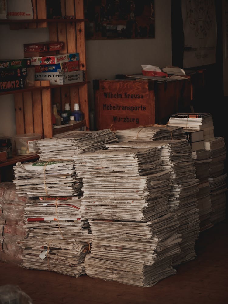 Stack Of Newspapers And Board Games On A Shelf