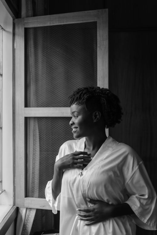 Free Black and white of cheerful African American female looking away and smiling in home Stock Photo