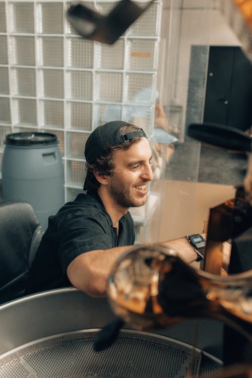 Free Man Operating a Machine at a Coffee Roasting Factory  Stock Photo