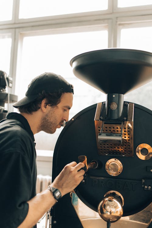 Man Operating a Machine at a Coffee Roasting Factory 