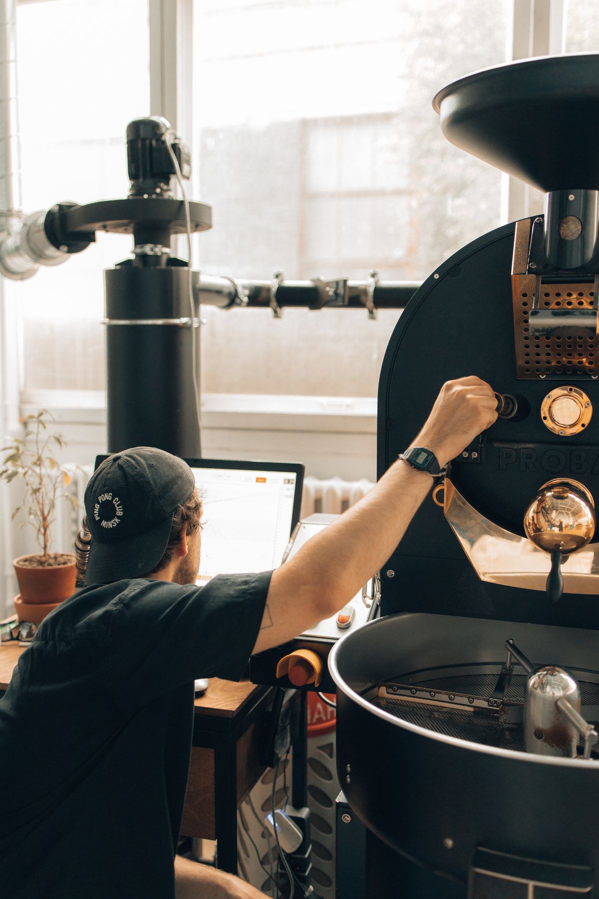 Adjusting controls on a small-batch roaster, for illustration