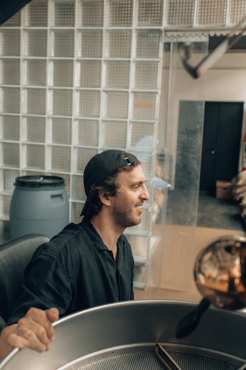 Man Operating a Machine at a Coffee Roasting Factory 