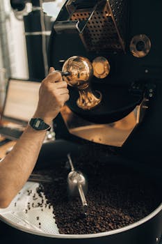 Detailed image of a coffee roaster machine in operation at a modern coffee factory.