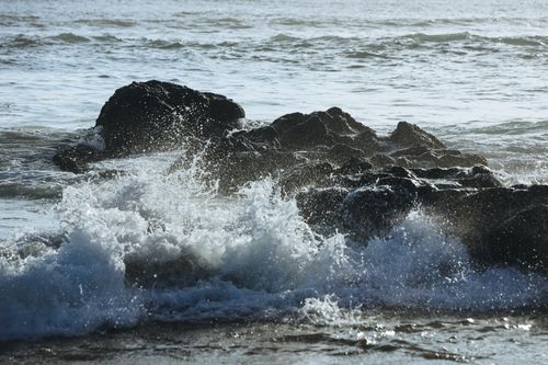 Free Dramatic scene of ocean waves crashing over jagged rocks at the seacoast, creating a refreshing and wild atmosphere. Stock Photo