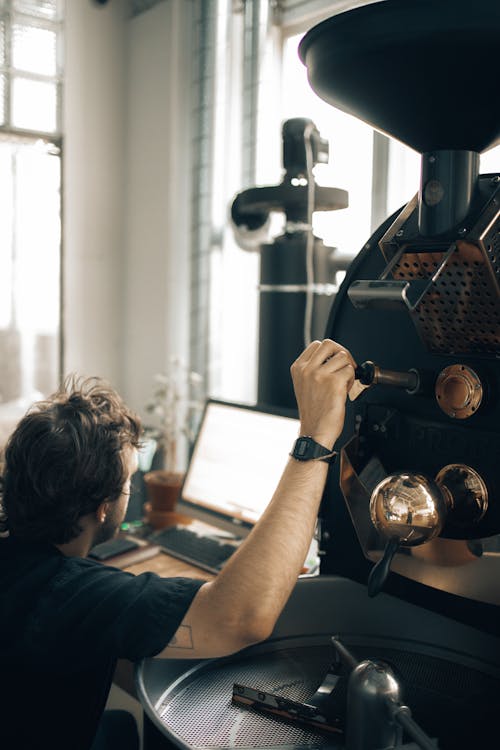 Man Operating a Machine at a Coffee Roasting Factory 