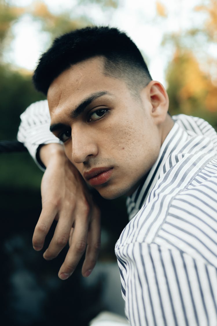 Photo Of A Young Man In A Striped Shirt Posing Outside 