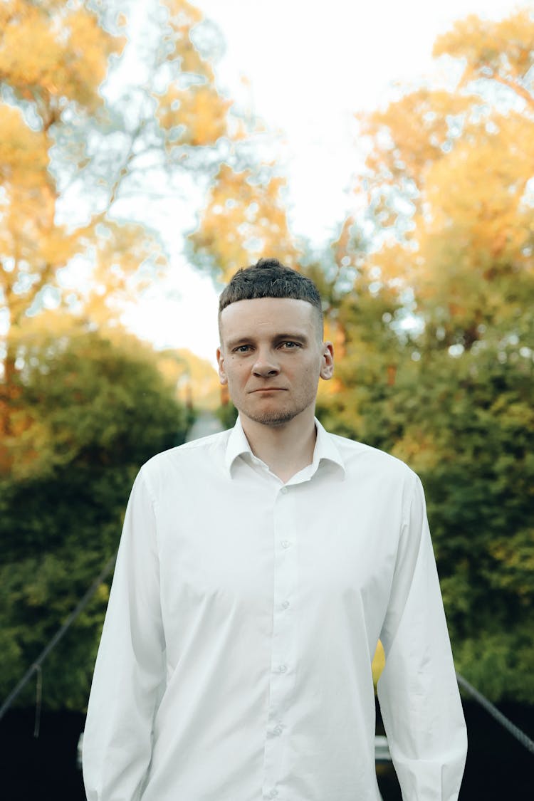 Young Man In A White Shirt Posing Outside 