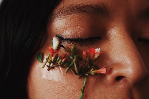 Woman With White and Red Flowers on Face