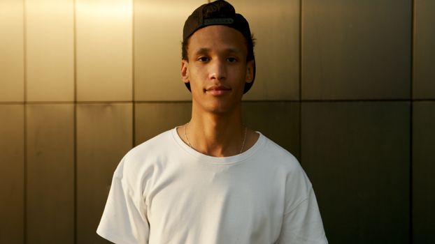 Portrait of a young man in casual attire with a serene background.