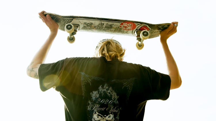 Photo Of Person Carrying A Skateboard