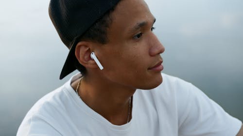 A Close-Up Shot of a Man Wearing Wireless Earphones