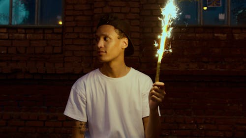 Man in White Crew Neck T-shirt Holding Fire