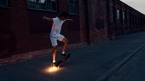 Man in White Shirt and White Shorts Riding Skateboard