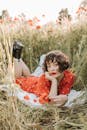 一位时尚女士身穿红色圆点连衣裙，在野花丛中放松身心，尽显夏日宁静氛围