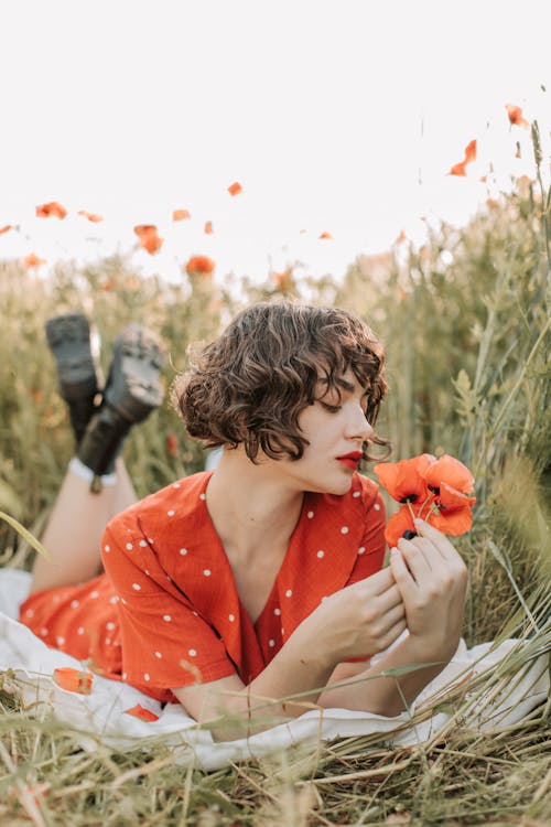 Beautiful Woman Looking at Red Poppies
