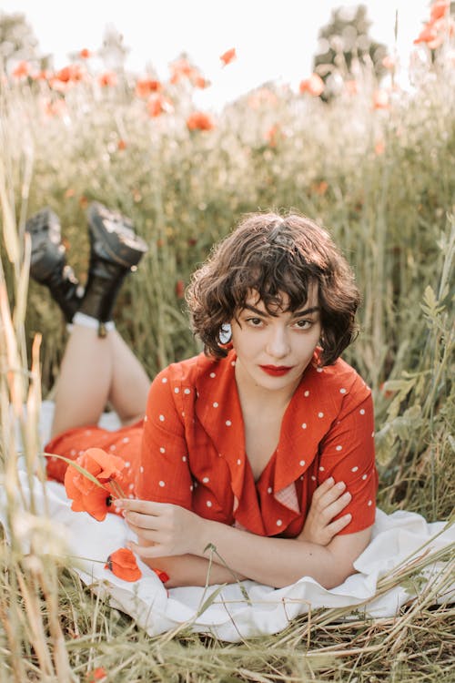 Beautiful Woman in Red Polka Dot Dress Posing with Her with Arms Crossed