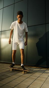 年轻人在城市环境中穿着休闲白色服装玩滑板