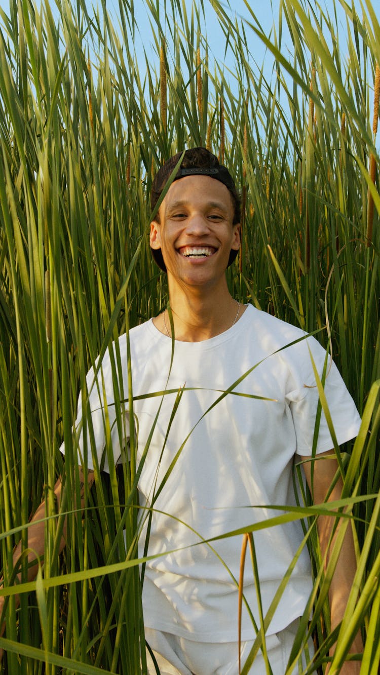 A Smiling Man Surrounded By Tall Grasses