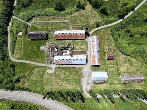 Aerial View of Barns on Green Grass Field
