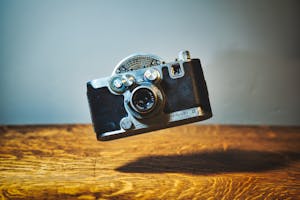 Retro photo camera above wooden table