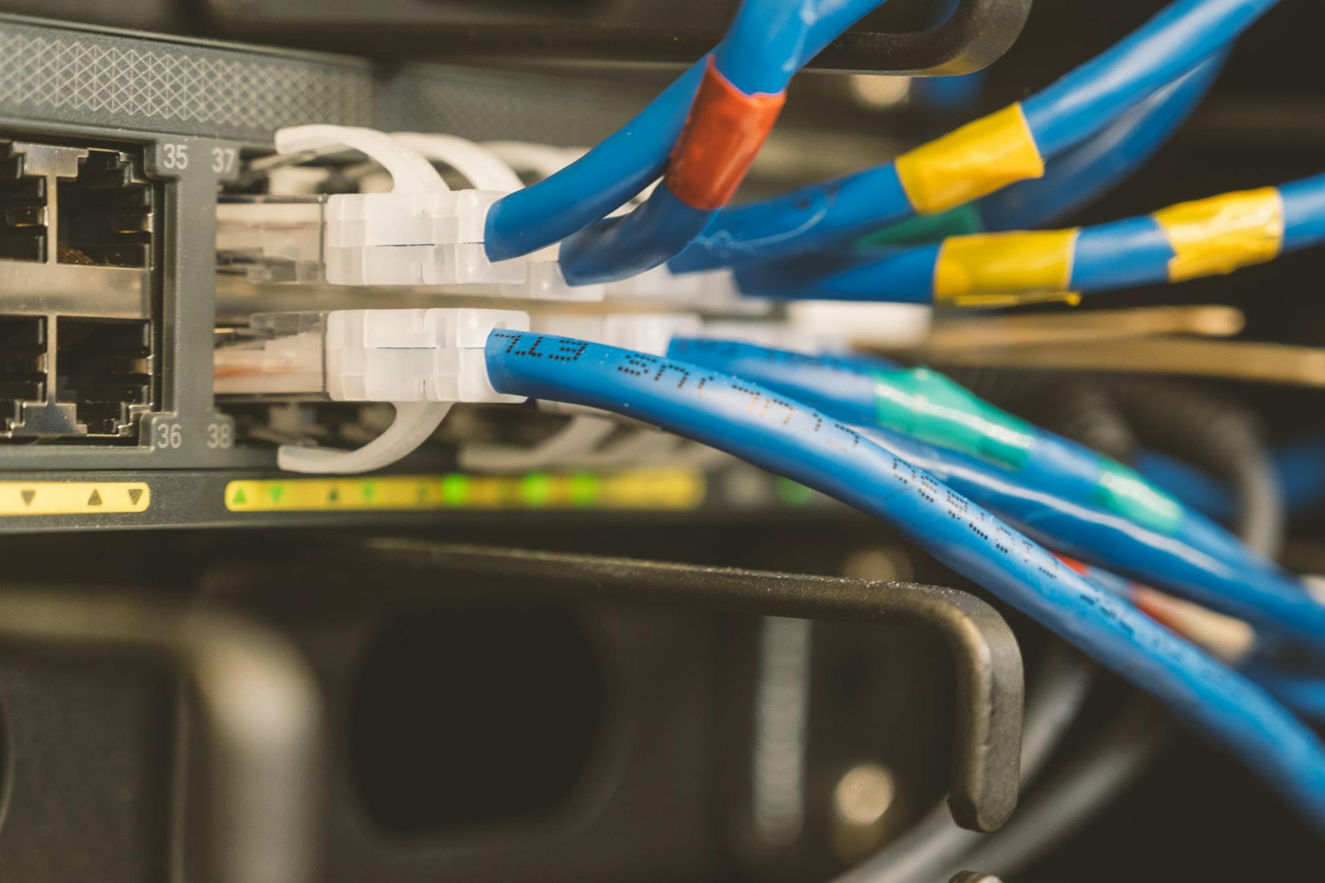 Detailed view of ethernet cables plugged into a network switch, highlighting data connectivity.