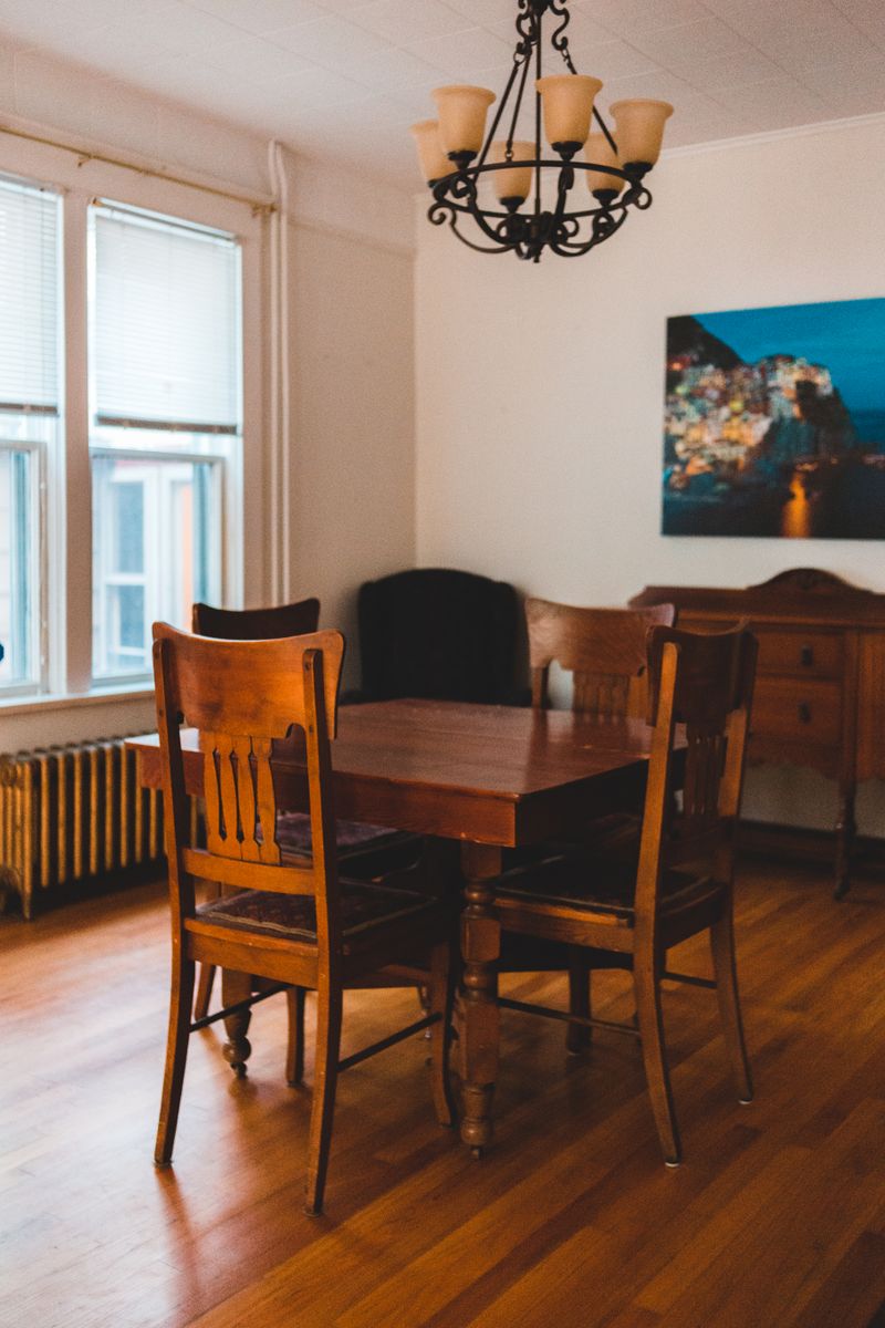 Warm vintage dining corner with wooden table, chairs and pendant light