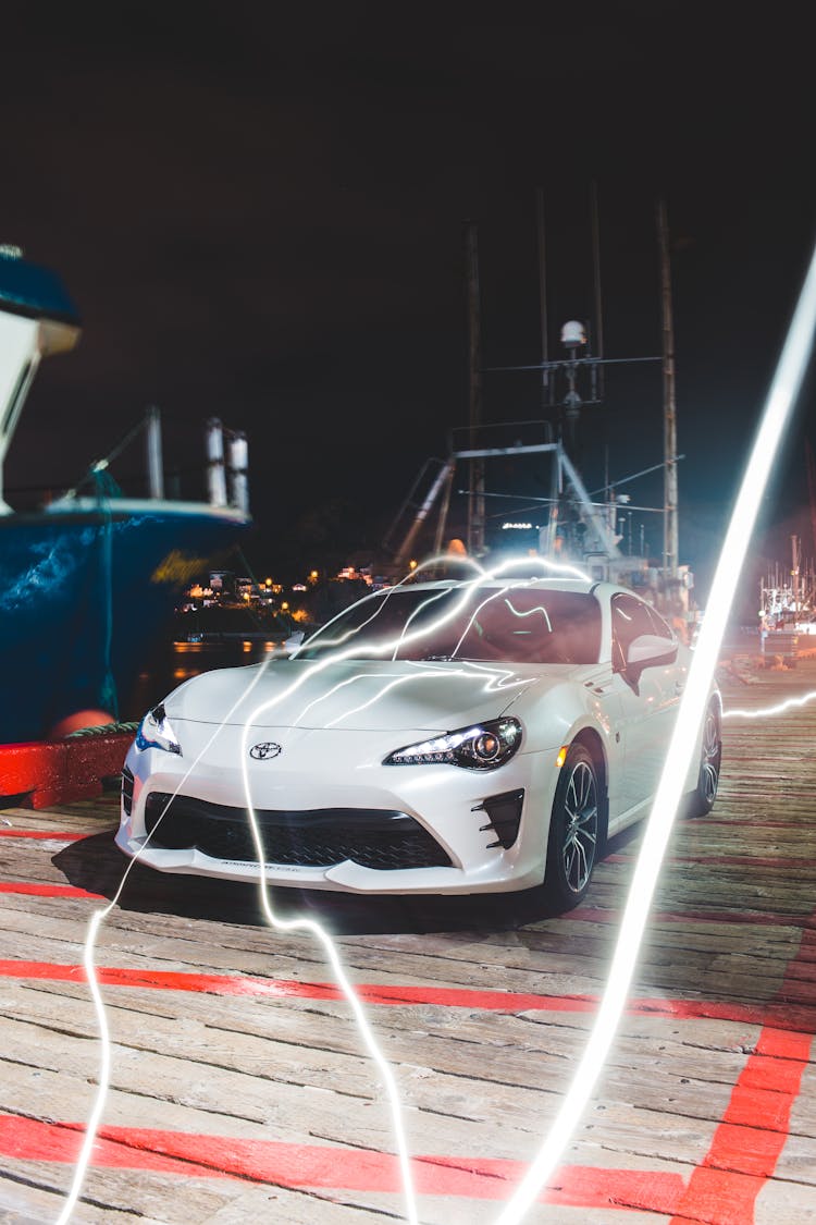 Modern Coupe Car Parked Near Port In Evening