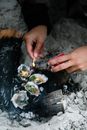 特写镜头：手在沙滩上点燃牡蛎烤架