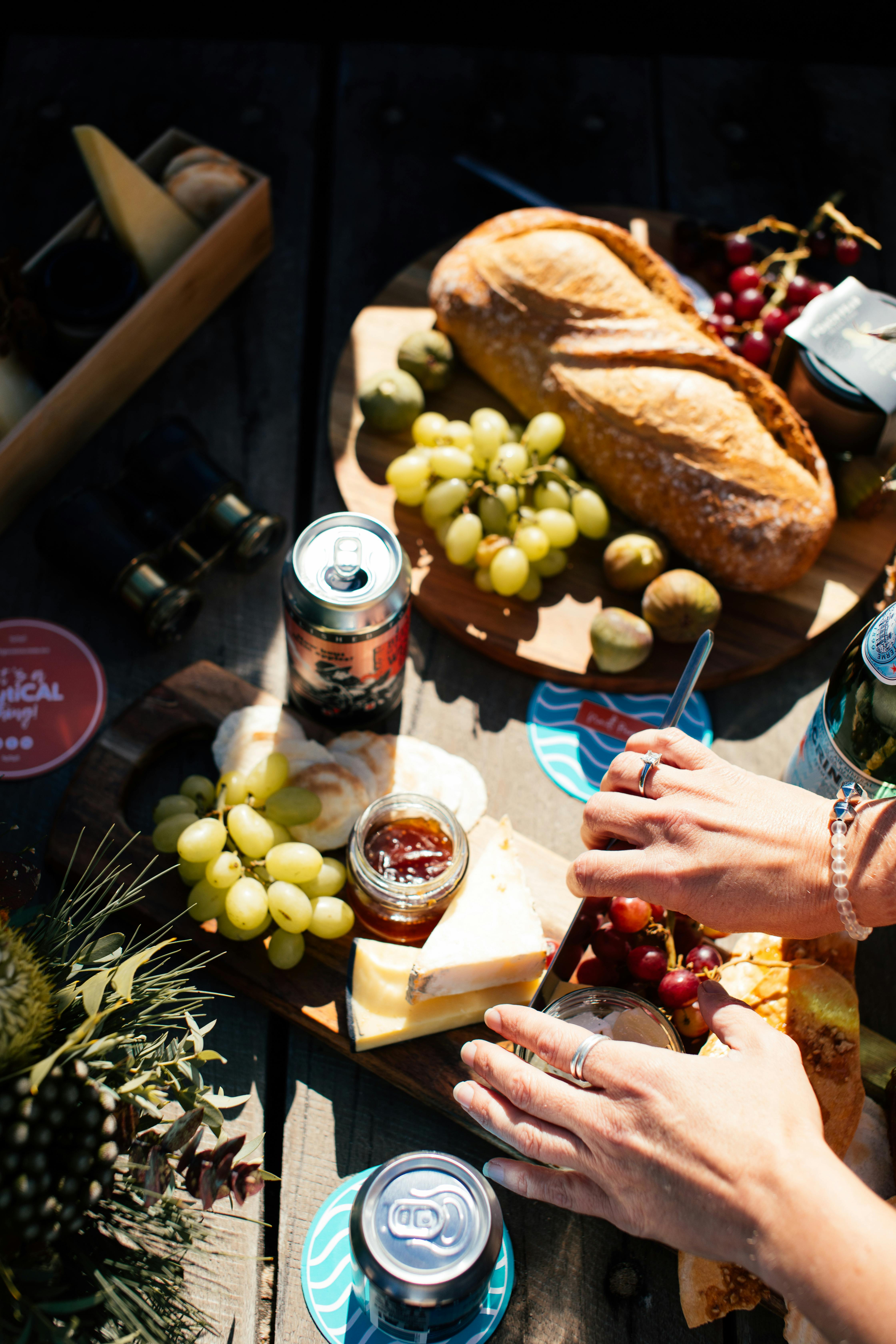 在阳光明媚的日子里，准备好美味的野餐，上面有面包、葡萄、奶酪和饮料