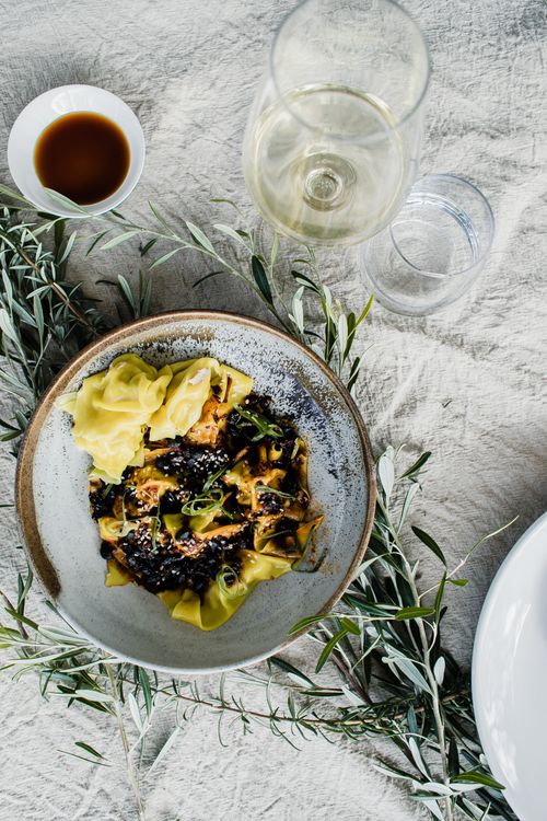 Free Top view of gourmet dumplings with a glass of white wine and green leaves for decoration. Stock Photo
