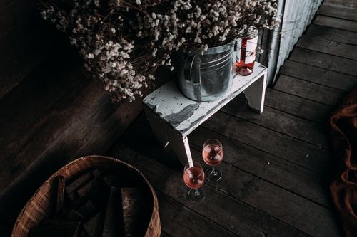 Free From above of transparent clean glasses of wine standing near wicker basket on wooden floor Stock Photo