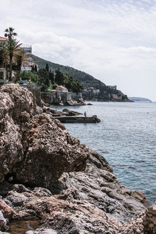 Free Amazing view from rough rocky coast on rippling blue sea water near small coastal town Stock Photo