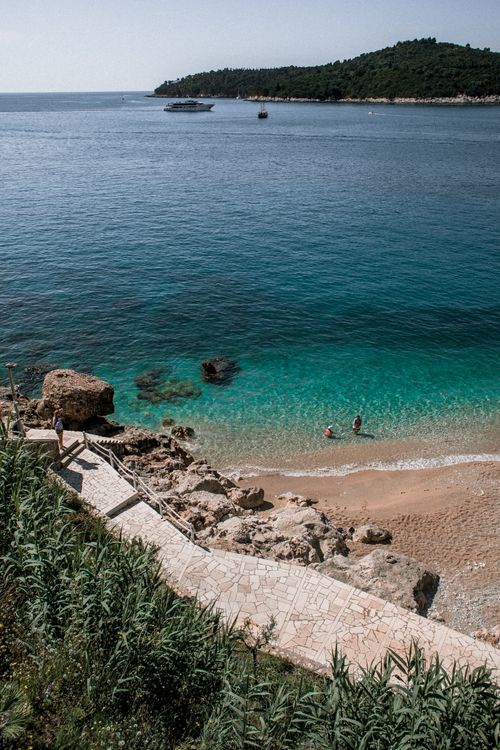 Free From above picturesque seascape of turquoise clear water washing sandy coast with rocks Stock Photo