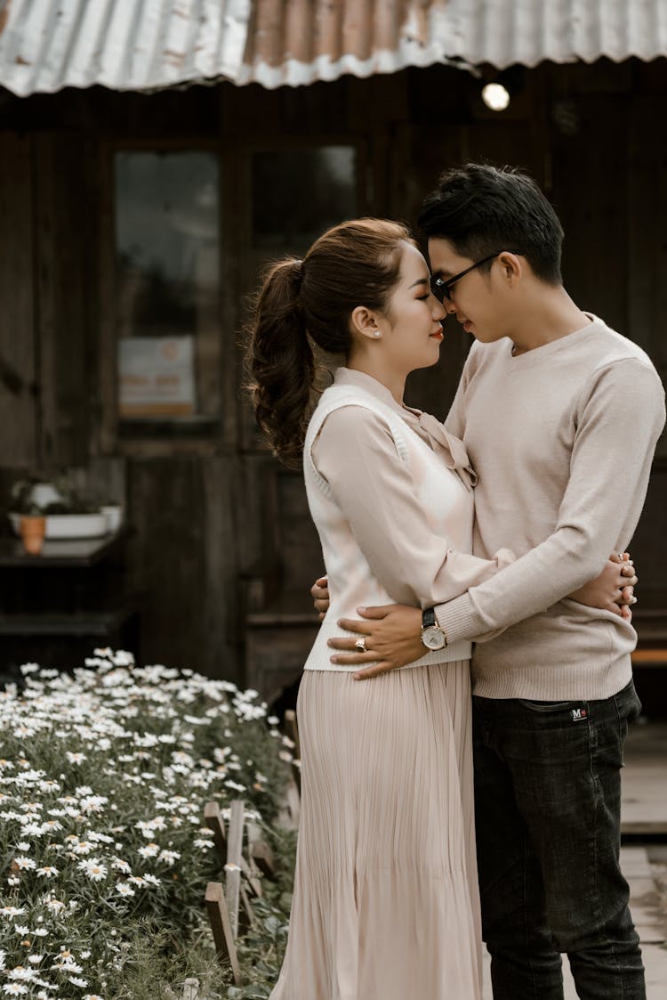 Young Asian Couple Embracing In Yard