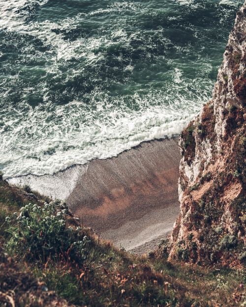 Free A breathtaking view of cliffs and crashing ocean waves on the beach of Étretat, Normandy. Stock Photo